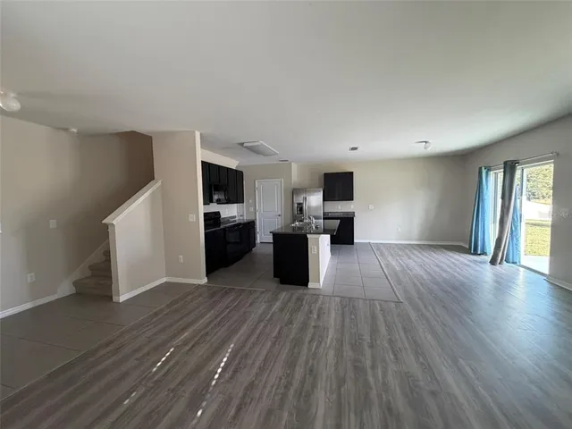 a view of a kitchen with wooden floor and electronic appliances