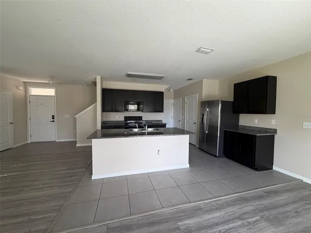 a large white kitchen with a refrigerator a stove top oven a sink and dishwasher