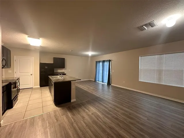 a view of kitchen with microwave a stove and wooden floor