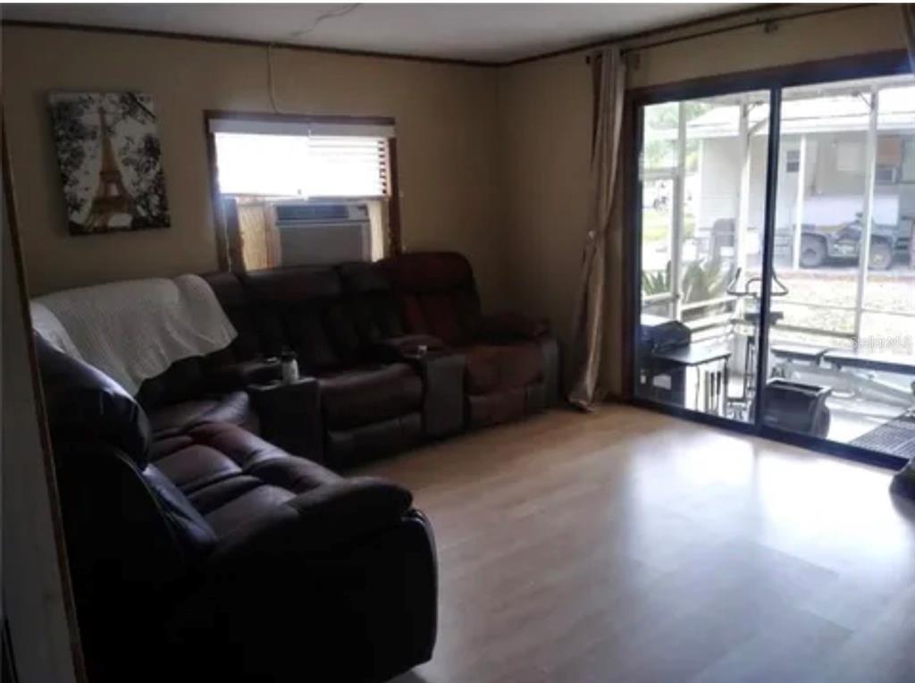8944 Jericho Court Polk City, FL 33868 - Photo 3 of 5 a living room with furniture and a floor to ceiling window