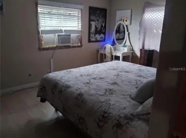 a bed sitting in a bedroom next to a window
