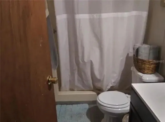a white toilet sitting next to a shower curtain