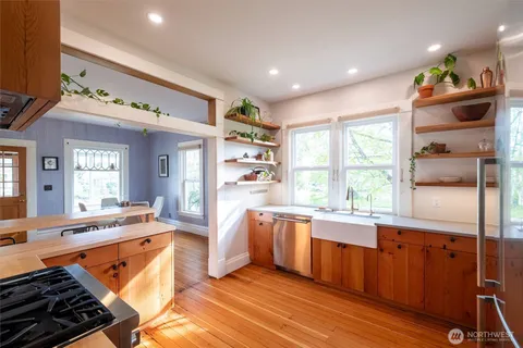 a large kitchen with stainless steel appliances granite countertop a stove and a large window