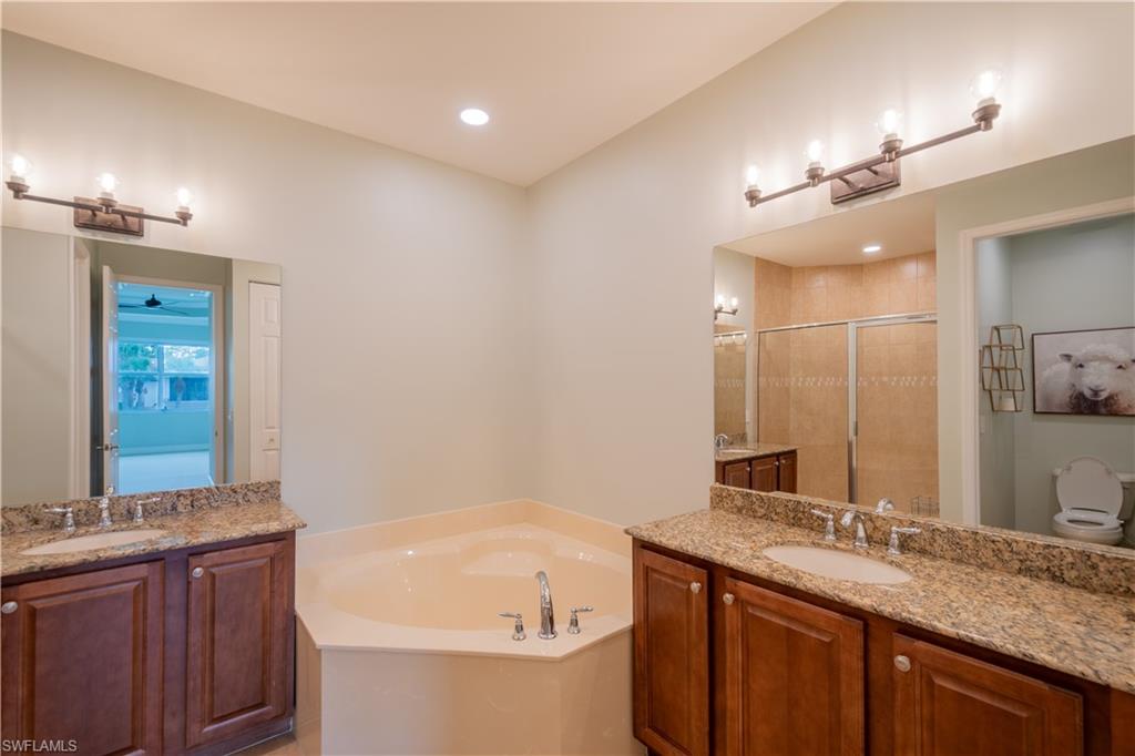 6533 Monterey Point, Unit 204 Naples, FL 34105 - Photo 11 of 41 a bathroom with a granite countertop bathtub sink vanity and mirror