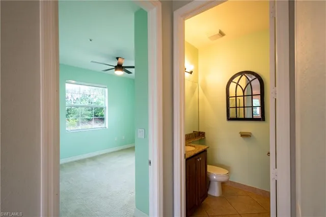 an empty room with a window and a fan