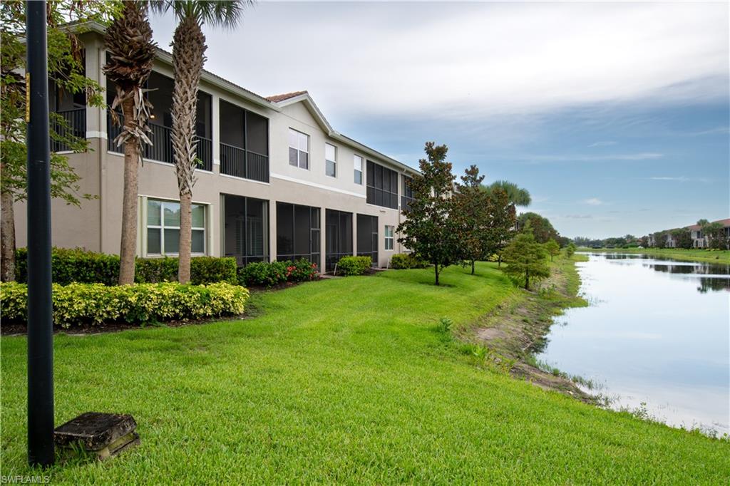 6533 Monterey Point, Unit 204 Naples, FL 34105 - Photo 2 of 41 a front view of a house with a yard and lake view