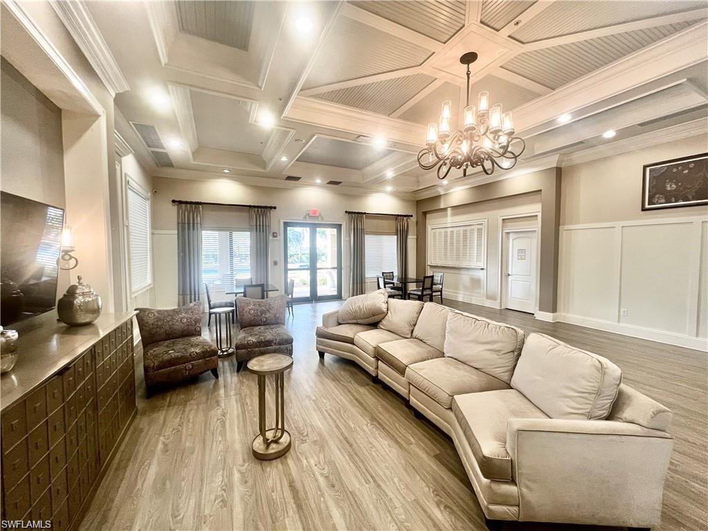 6533 Monterey Point, Unit 204 Naples, FL 34105 - Photo 39 of 41 a living room with furniture and a chandelier