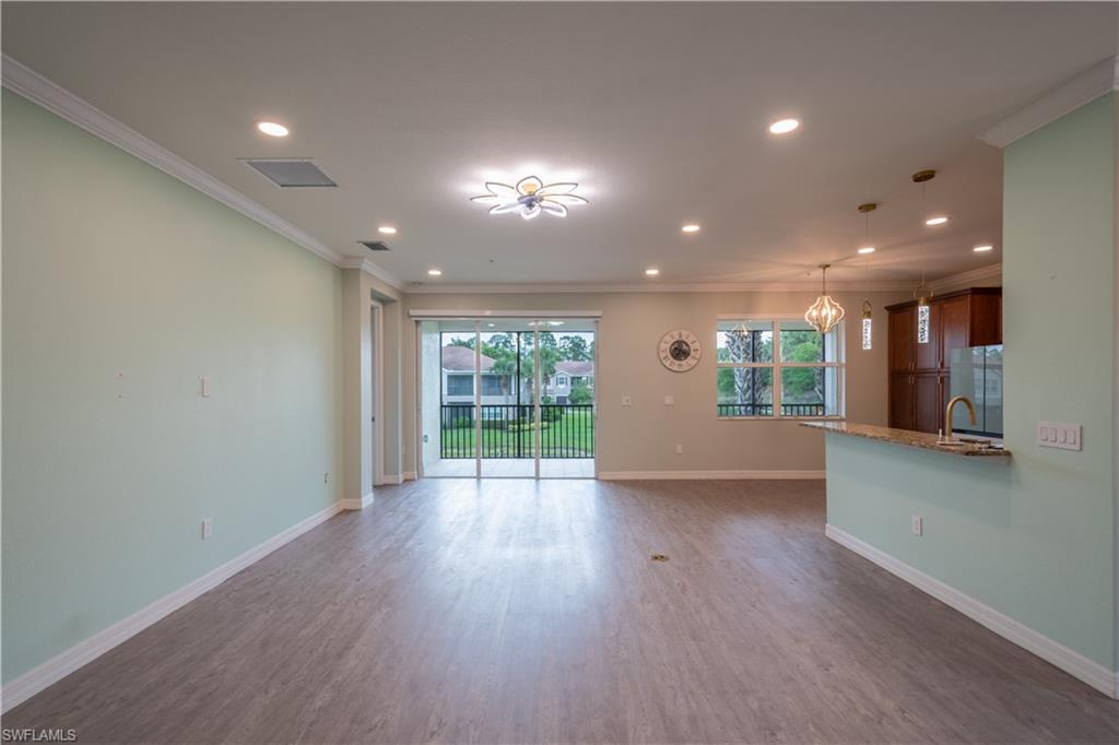 6533 Monterey Point, Unit 204 Naples, FL 34105 - Photo 5 of 41 a view of an empty room with wooden floor and a window