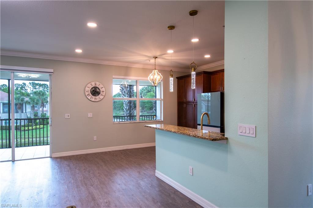 6533 Monterey Point, Unit 204 Naples, FL 34105 - Photo 7 of 41 a view of an empty room with wooden floor and a window