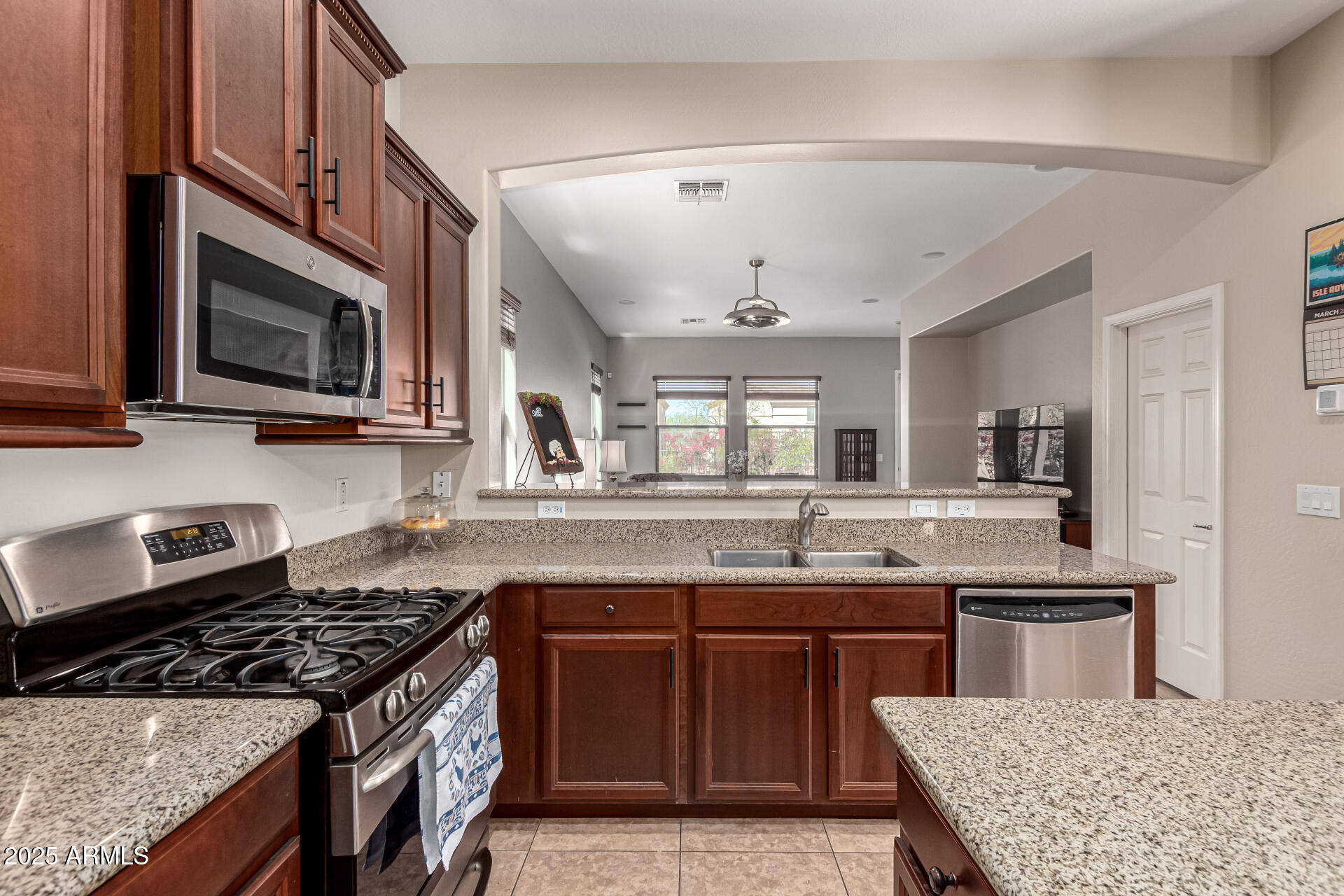 3914 East Constance Way Phoenix, AZ 85042 - Photo 34 of 81 a kitchen with kitchen island granite countertop a sink and steel appliances