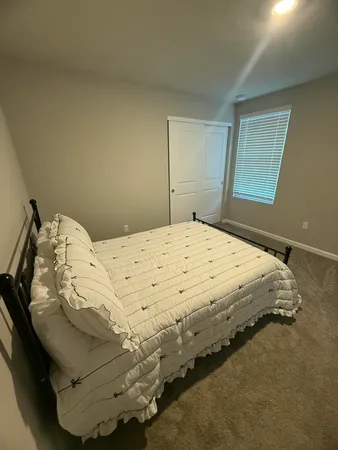 a bed sitting in a bedroom next to a window