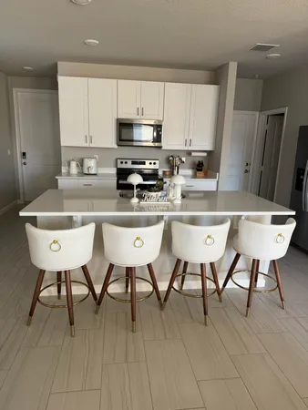 a kitchen with stainless steel appliances a table chairs refrigerator and sink