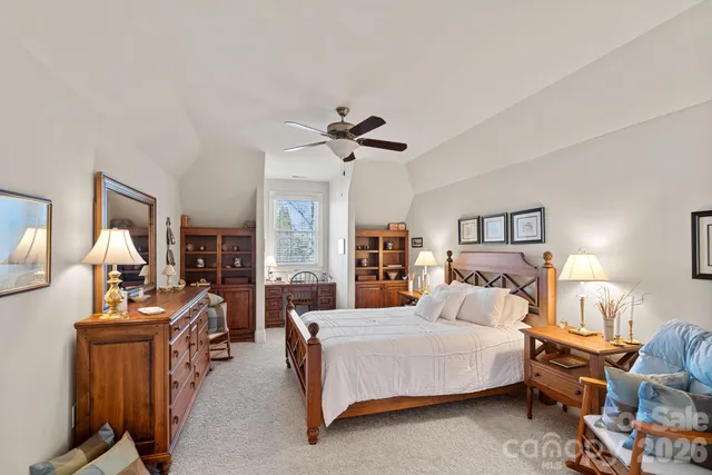 a bedroom with bed a flat tv screen and a dresser