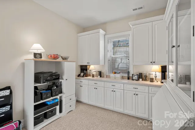 a kitchen with white cabinets and window