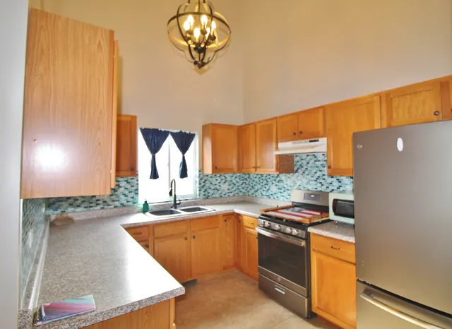 a kitchen with stainless steel appliances granite countertop a sink and a stove