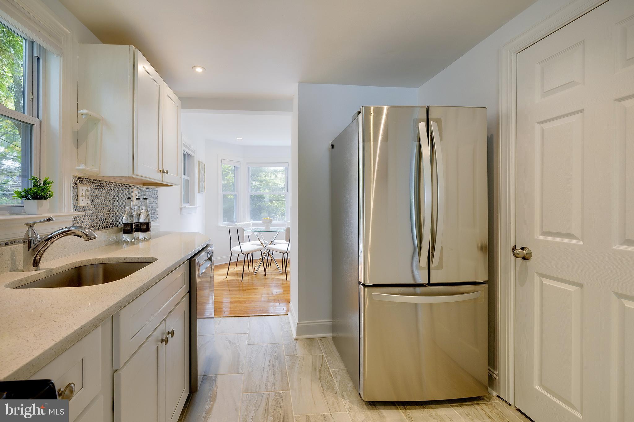 704 Maplewood Avenue Takoma Park, MD 20912 - Photo 18 of 54 a kitchen with kitchen island granite countertop a refrigerator and a sink
