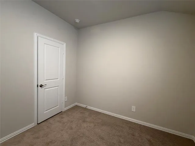 an empty room with closet and a bathroom