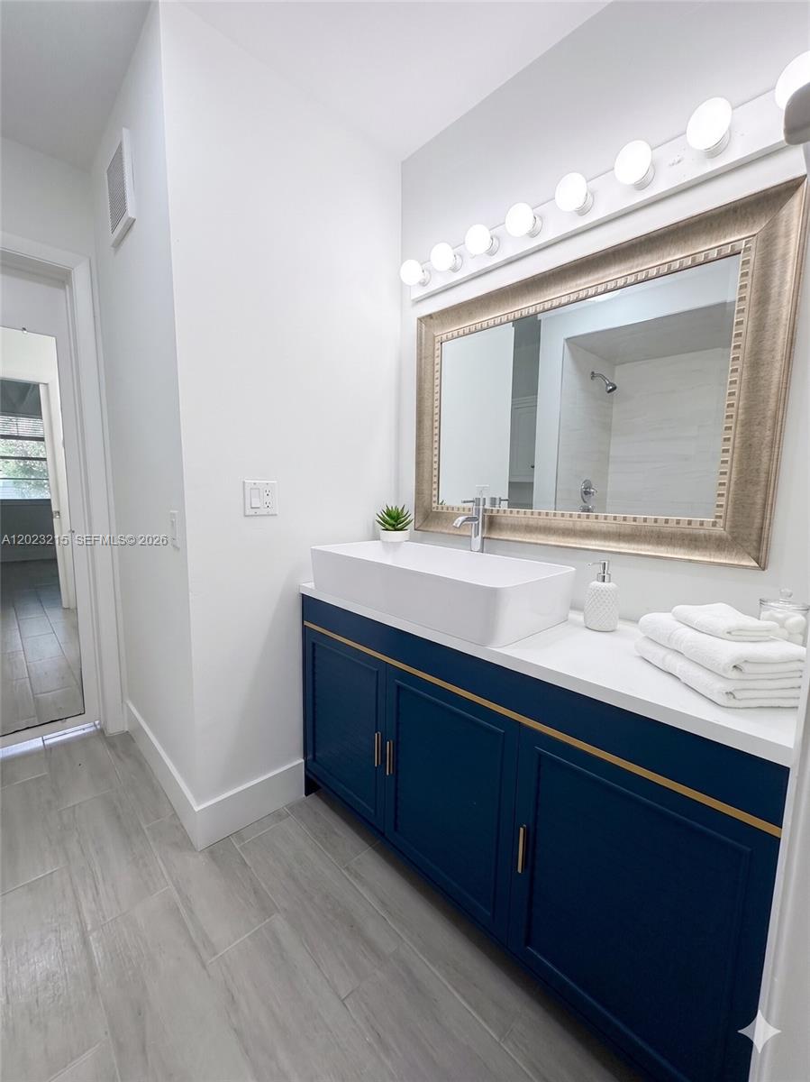 13 Southwest 3rd Street, Unit 13 Pompano Beach, FL 33060 - Photo 24 of 44 a bathroom with a granite countertop sink and a mirror