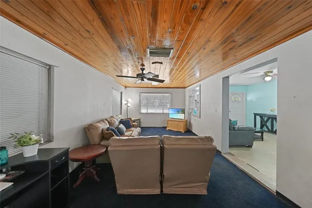 a living room with furniture a chandelier and a dining room