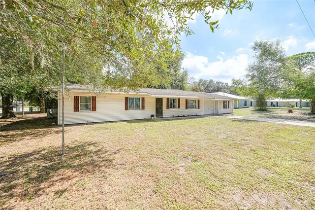 a backyard of a house with table and chairs