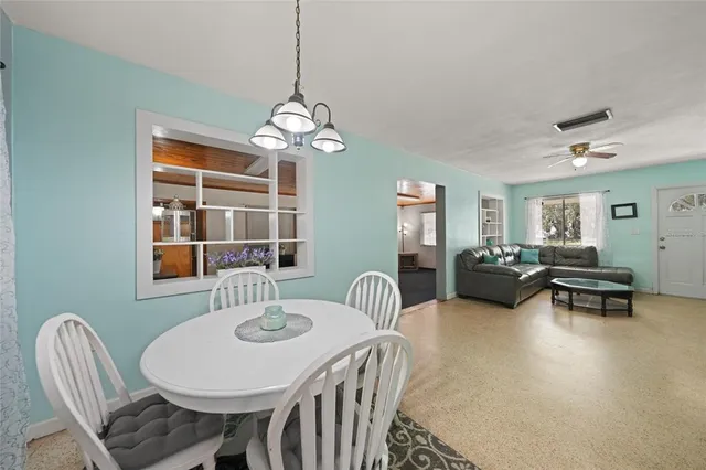 a view of a dining room with furniture a chandelier and window