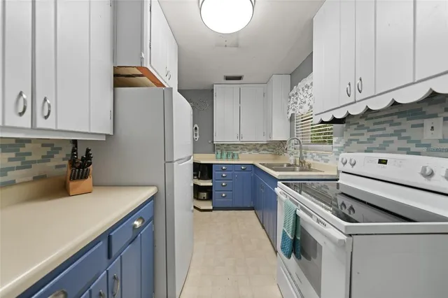 a kitchen with a sink a stove and cabinets