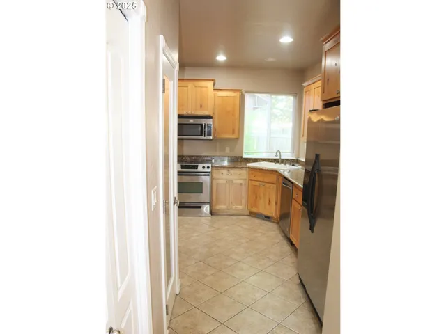 a kitchen with stainless steel appliances granite countertop a refrigerator and a sink