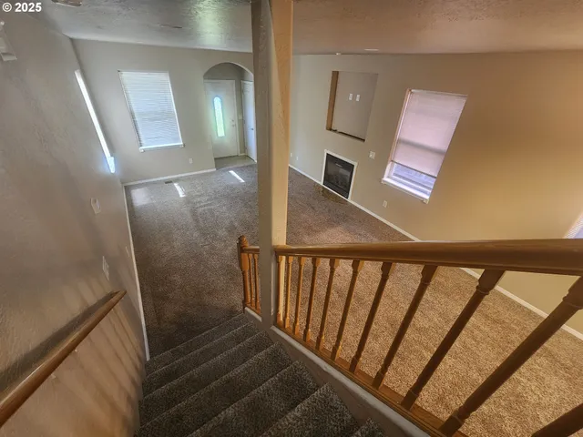 a view of a hallway with wooden floor and stairs
