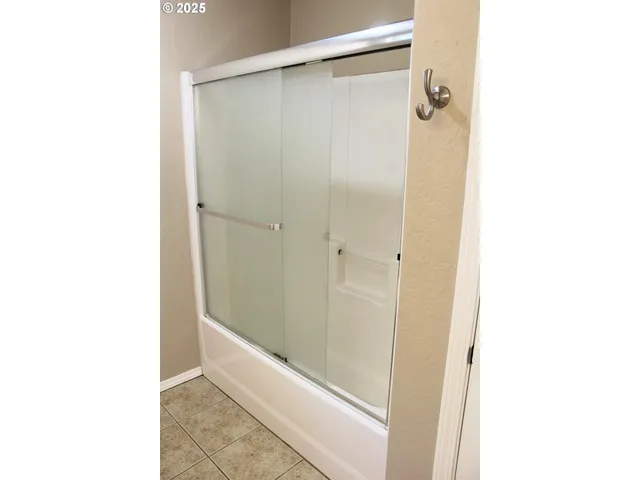 a bathroom with a shower and a room