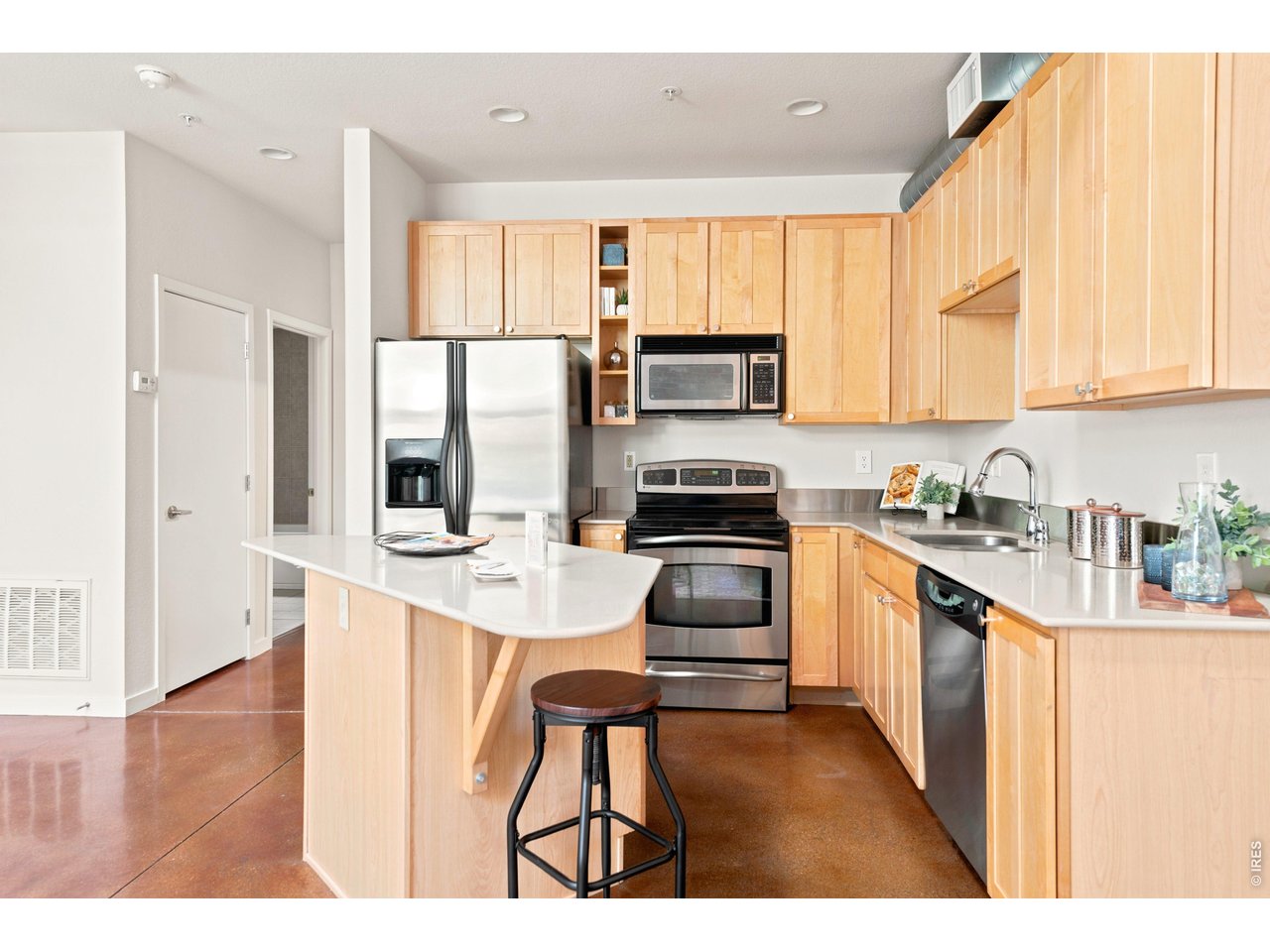 3033 Blake Street, Unit 112 Denver, CO 80205 - Photo 11 of 28 a kitchen with kitchen island granite countertop a sink appliances cabinets and a counter top space