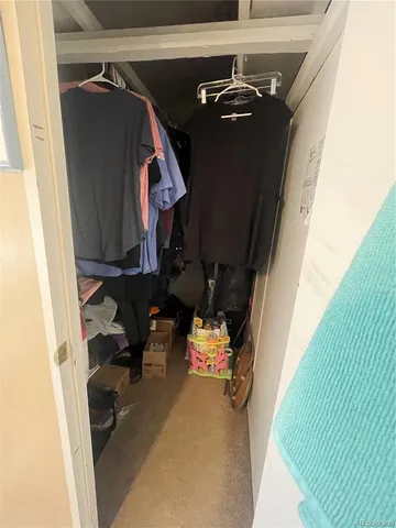 a view of walk in closet with clothes and shoes