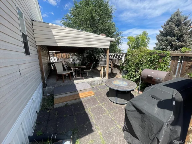 a view of a patio with table and chairs with wooden floor and fence
