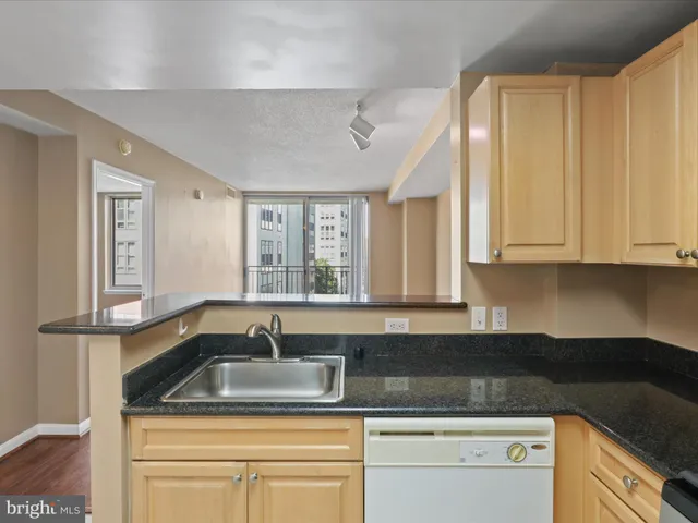 a kitchen with granite countertop a sink and white cabinets