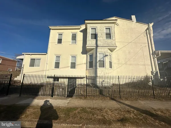 a view of a white house with iron fence