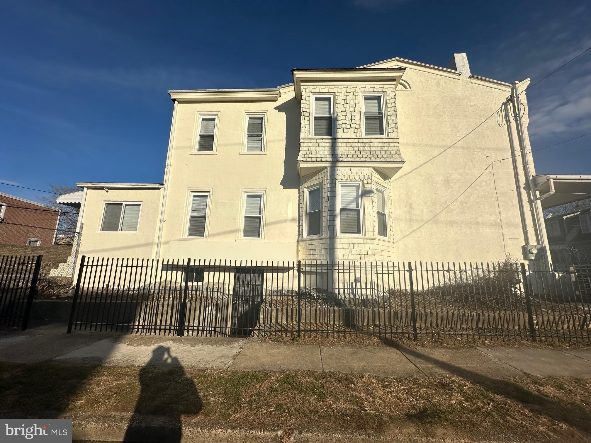 a view of a white house with iron fence