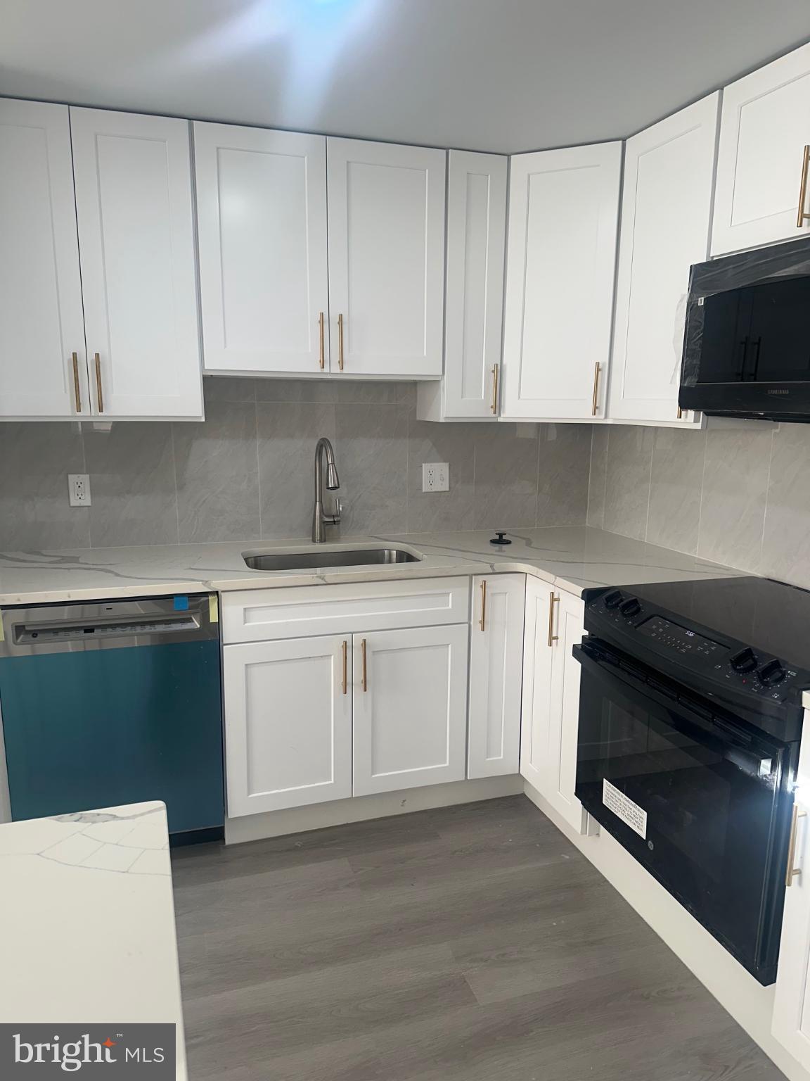 5100 Cottage Street Philadelphia, PA 19124 - Photo 8 of 20 a kitchen with granite countertop white cabinets and stainless steel appliances