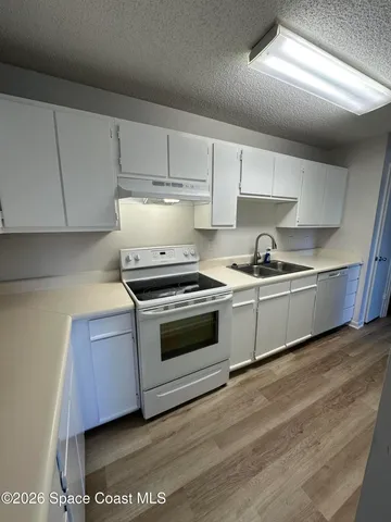 a kitchen with stainless steel appliances a sink a stove and cabinets