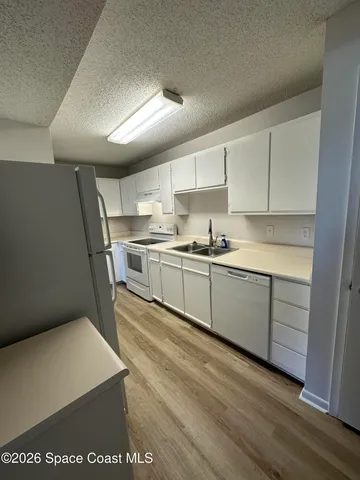 a kitchen with stainless steel appliances granite countertop a sink a stove a refrigerator with grey cabinets