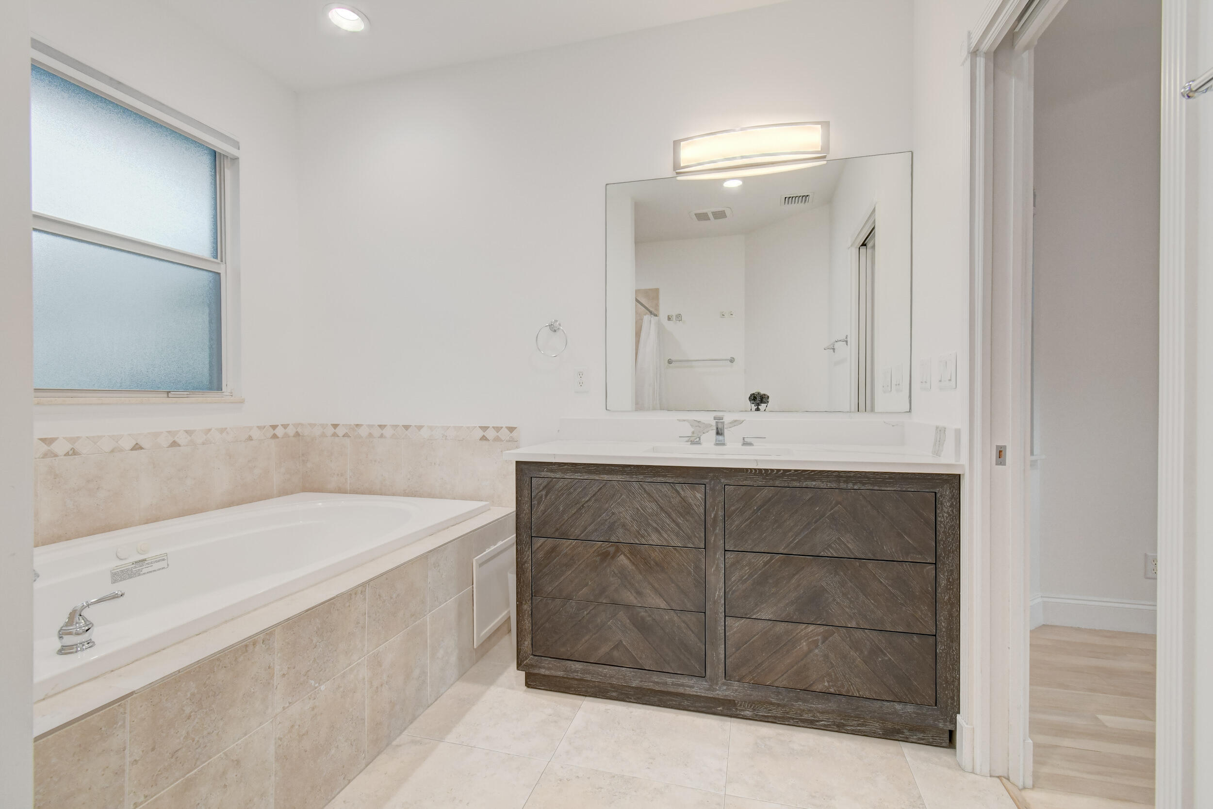 21 Oceanview Drive, Unit C Ocean Ridge, FL 33435 - Photo 17 of 17 a bathroom with a bathtub sink and mirror