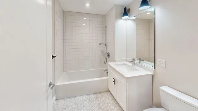 a bathroom with a tub sink toilet and a mirror