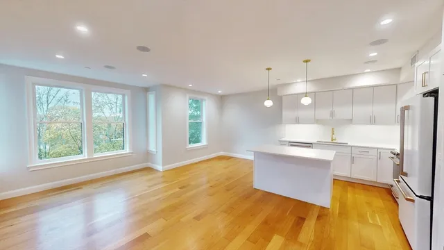 a large kitchen with stainless steel appliances granite countertop a stove and a large window