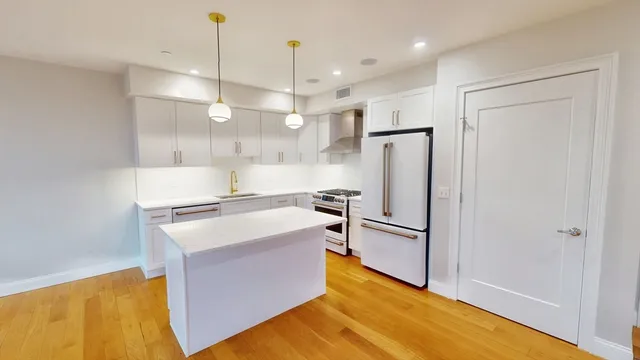 a kitchen with stainless steel appliances granite countertop a refrigerator a sink and a stove