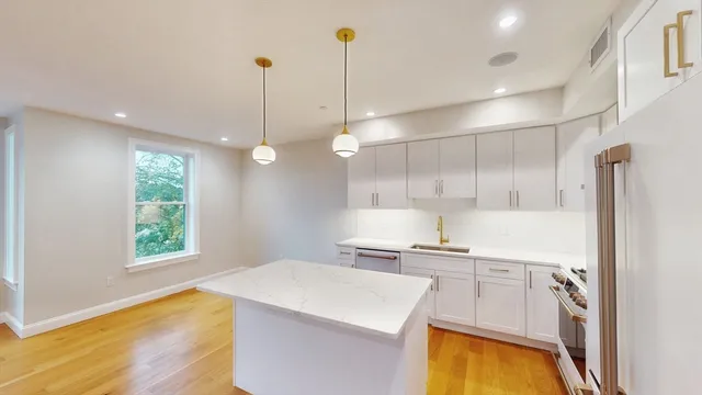 a kitchen with a sink a stove a refrigerator and a window
