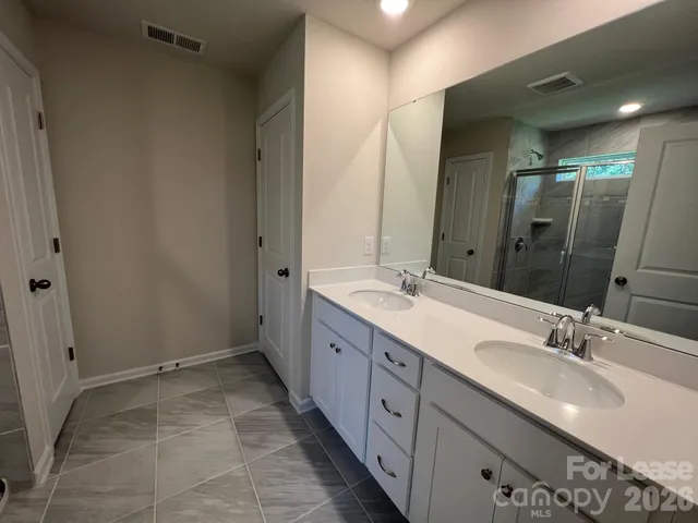 a spacious bathroom with a double vanity sink mirror and double