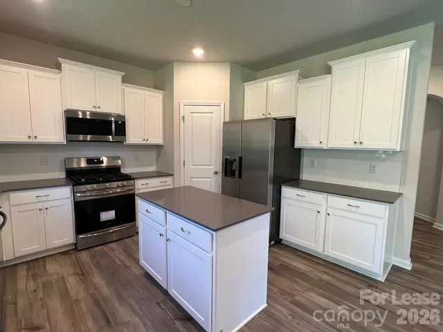 a kitchen with stainless steel appliances granite countertop a refrigerator stove microwave and sink