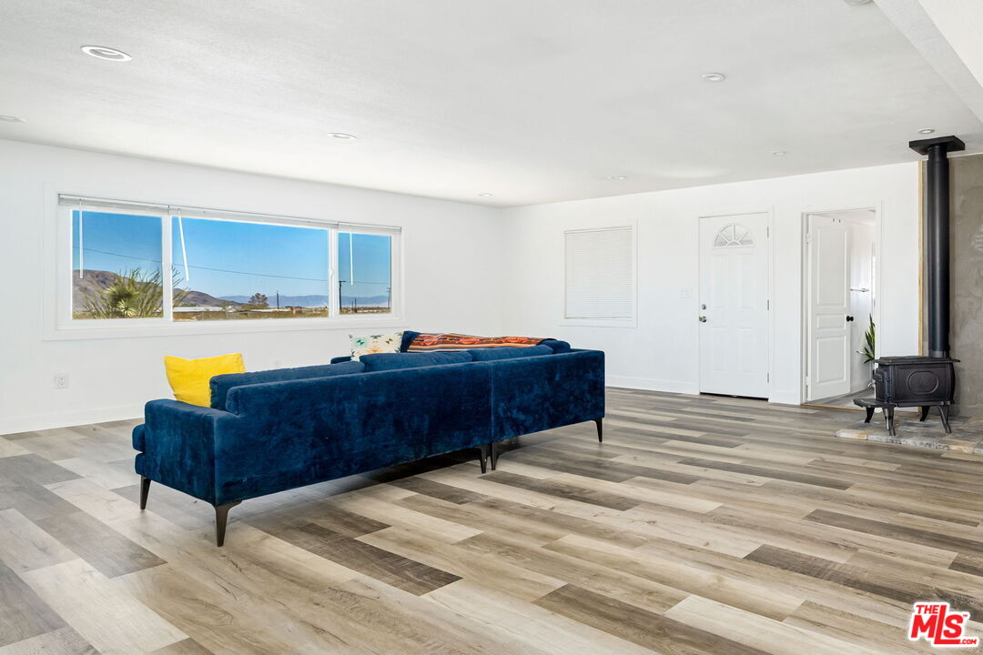 57157 Emerald Way Landers, CA 92285 - Photo 3 of 12 a living room with couches and kitchen view with wooden floor