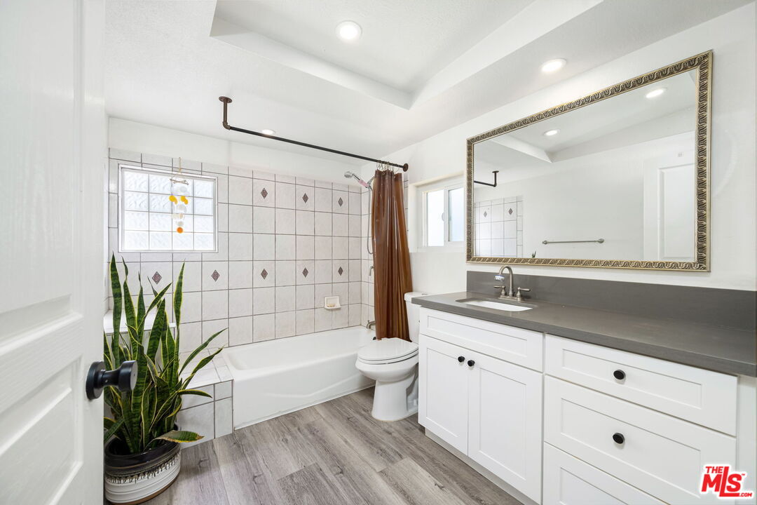 57157 Emerald Way Landers, CA 92285 - Photo 5 of 12 a bathroom with a granite countertop sink a toilet a mirror a vanity and shower