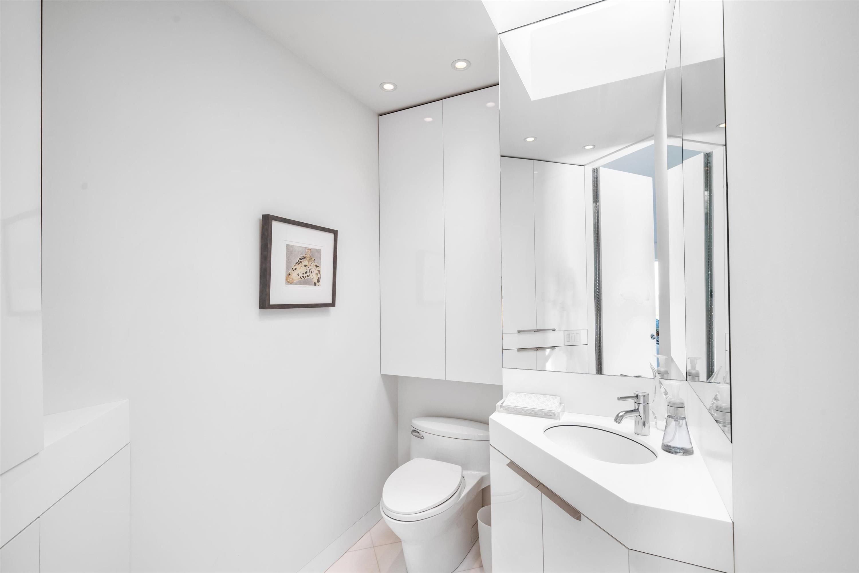 103 116th Street Stone Harbor, NJ 08247 - Photo 20 of 49 a bathroom with a sink a toilet and a large mirror