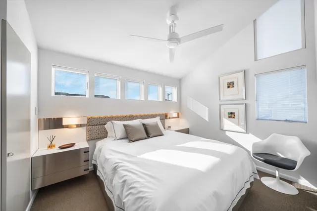 a bedroom with a bed a large window and a flat screen tv