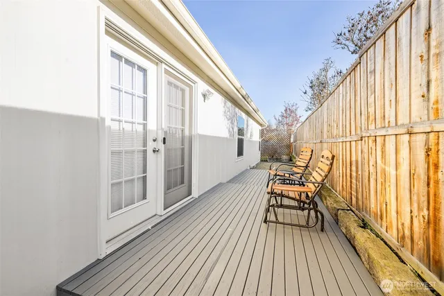 a view of balcony with wooden floor and fence and a floor to ceiling window